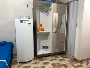 a refrigerator in a kitchen next to a cabinet at Kitnet- Edícula em Fazendinha in Macapá