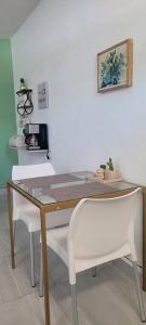 stół i 2 białe krzesła w pokoju w obiekcie Estudio Biznaga w mieście San José del Cabo