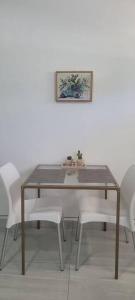 tavolo da pranzo con sedie bianche e quadro di Estudio Biznaga a San José del Cabo