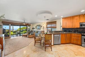 a kitchen with wooden cabinets and a living room at Kaanapali Plantation 57 in Lahaina