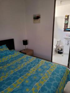 a bedroom with a bed with a blue and yellow comforter at Apartamento Tranquilo para Descansar in Sincelejo
