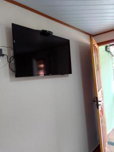 TV de pantalla plana colgada en la pared en Hospedagem Frez en Nova Friburgo