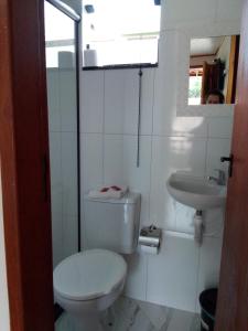 Baño blanco con aseo y lavamanos en Hospedagem Frez en Nova Friburgo