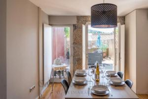 a dining room with a table and chairs and a room with a window at Casa Porta Nova AL in Guimarães