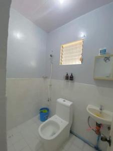 a white bathroom with a toilet and a sink at AB Yam Staycation Gensan (can accommodate up to 15 pax) in General Santos
