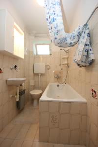 a bathroom with a tub and a toilet and a sink at Apartments with a parking space Fazana - 7230 in Marana