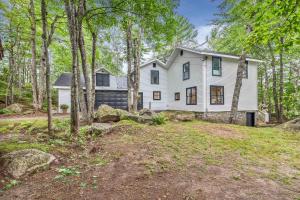 a white house in the woods with trees at Chuck's Place in Dedham