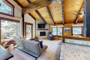 a living room with wooden ceilings and a fireplace at Pine Haven Retreat in Stateline