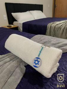 a towel on a bed in a hotel room at Pousada Estrela de Davi in Penha