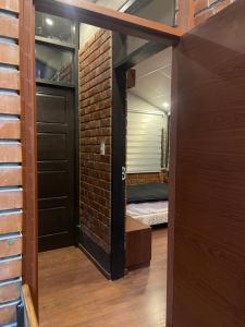 a room with a bed and a brick wall at Onkel Inn Wagon Sleepbox Uyuni in Uyuni