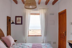 a bedroom with a window with a view of the beach at Hotel D' Interior Can Colom in Banyalbufar