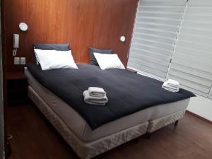 Una cama en una habitación con toallas. en Onkel Inn Wagon Sleepbox Uyuni, en Uyuni