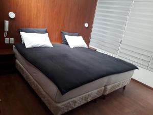 a bed with two pillows on it in a bedroom at Onkel Inn Wagon Sleepbox Uyuni in Uyuni