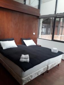 uma cama grande com duas toalhas num quarto em Onkel Inn Wagon Sleepbox Uyuni em Uyuni