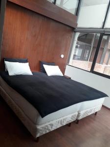 1 dormitorio con 1 cama grande y cabecero de madera en Onkel Inn Wagon Sleepbox Uyuni, en Uyuni