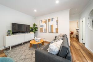a living room with a couch and a tv at One Tea House - Contemporary Cityside Comfort in Keswick