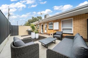 a patio with a couch and chairs and a table at The Tea House - Apartment 1 in Keswick