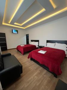 een hotelkamer met 2 bedden en een bank bij HOSTAL DEL RIO in Gualaceo