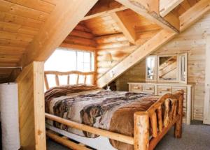 Een bed of bedden in een kamer bij Peaceful Log Cabin in the Woods. 20 miles from ski resorts. Family Friendly!