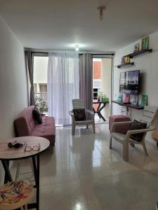 a living room with a pink couch and chairs at Apartamento Tranquilo para Descansar in Sincelejo