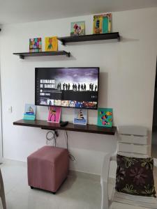 a television on a wall with a chair and a bench at Apartamento Tranquilo para Descansar in Sincelejo