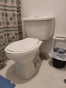 a white toilet in a bathroom with a shower curtain at Apartamento Tranquilo para Descansar in Sincelejo