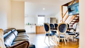 a living room with a couch and a table and chairs at Heritage Holiday House No.15 in Wonga Park