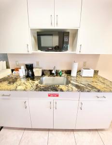 a kitchen counter with a sink and a microwave at Royal Inn Hotel in Royal Palm Beach