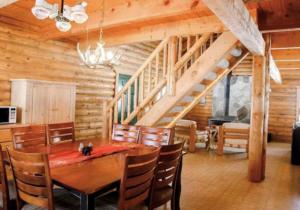 comedor con mesa y escalera en Peaceful Log Cabin in the Woods. 20 miles from ski resorts. Family Friendly!, en Heber City