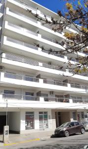 a car parked in front of a white building at Departamento Cofico in Cordoba +6 photos