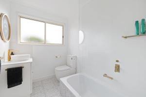 Un baño blanco con bañera y lavabo. en Lazy Daze at SummerHaze, en Cape Woolamai