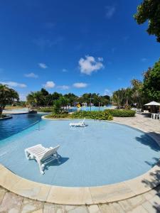 una gran piscina con un banco y una mesa en ILOA Condomínio Resort BARRA DE SÃO MIGUEL, Quarto em frente a piscina, en Barra de São Miguel