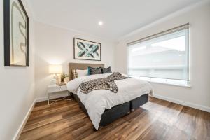a white bedroom with a bed and a window at Two Tea House - Contemporary Courtyard Comfort in Keswick