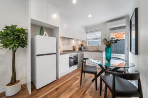 uma cozinha com uma mesa de vidro e um frigorífico branco em The Tea House - Apartment 2 em Keswick