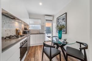 a kitchen with a glass table and chairs and a counter at Two Tea House - Contemporary Courtyard Comfort in Keswick +18 photos