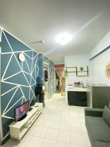 a living room with a couch and a kitchen at Cibubur Village Apartemen by Ar-Ramadhan in Cibubur