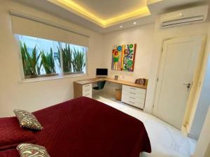 um quarto com uma cama, uma secretária e uma janela em Cozy and Deluxe Apartment at the Heart of Ipanema no Rio de Janeiro