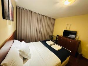 Habitación de hotel con cama y TV en Hotel Piru Wasi, en Arequipa