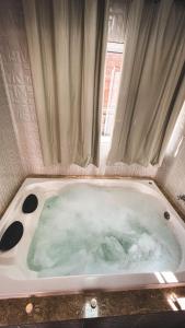 a bath tub filled with green water in a bathroom at Recanto Bella Fonte in Monte Verde