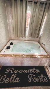 a bath tub with a sign in front of it at Recanto Bella Fonte in Monte Verde