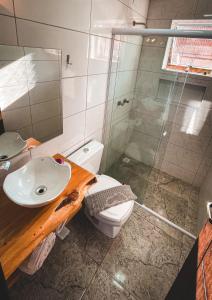 a bathroom with a toilet and a sink and a shower at Recanto Bella Fonte in Monte Verde