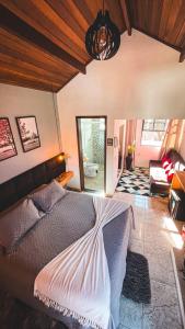 モンテ・ヴェルデにあるRecanto Bella Fonteのベッドルーム1室(ベッド1台付)、リビングルームが備わります。