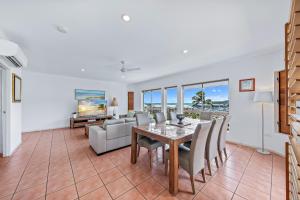 a dining room and living room with a table and chairs at Spa Haven 17A in Airlie Beach