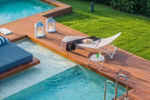 een zwembad met een terras met een tafel en stoelen erop bij Avaton Luxury Beach Resort - Relais & Chateaux in Ouranoupoli
