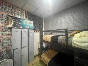1 dormitorio con 2 literas y pared de ladrillo en La casa de la 12 en Campeche