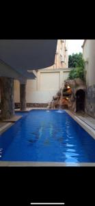 a large blue swimming pool with a water fountain at The Glasshouse Pools in Cairo