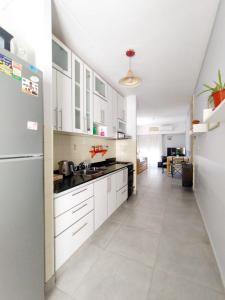 una gran cocina blanca con armarios y electrodomésticos blancos en Casa a tres cuadras del mar, en Puerto Madryn