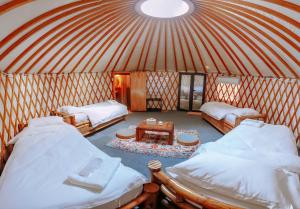 a room with two beds and a table in a yurt at Nomad Yurts in Coron