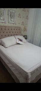 a bedroom with a white bed with a headboard at Apartamento 2 quartos com 1 suite in Serra