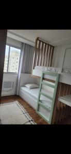 a small room with a bunk bed and a ladder at Apartamento 2 quartos com 1 suite in Serra